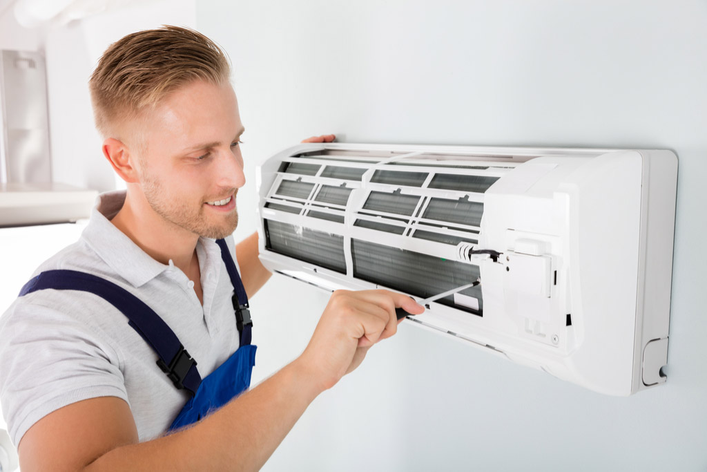 HVAC technician performing ductless air conditioning maintenance in West Jordan