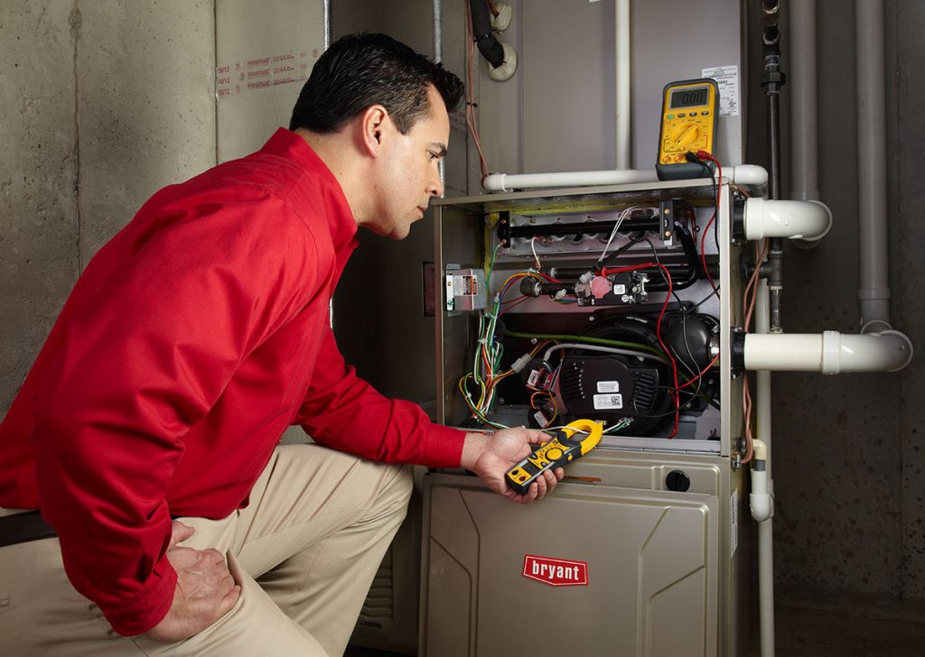 HVAC technician repairing an indoor furnace in West Jordan