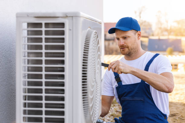 HVAC technician servicing an outdoor air conditioning unit in West Jordan