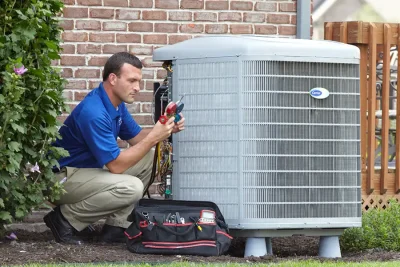 design-air-heating-and-air-conditioning-decatur-il-05 – Copy HVAC technician inspecting an outdoor air conditioning unit in West Jordan, UT